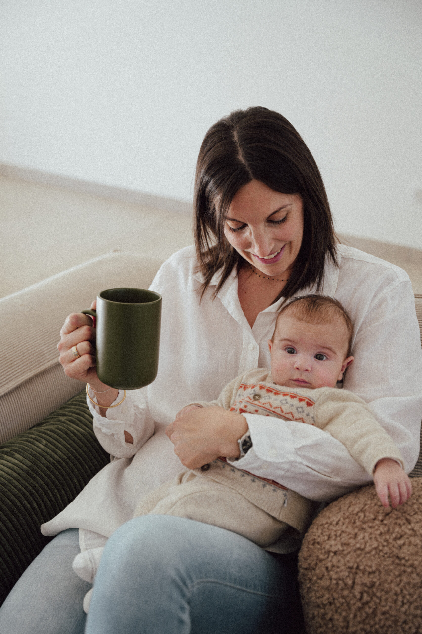 Maman tenant tendrement son bébé et buvant une tisane d'allaitement