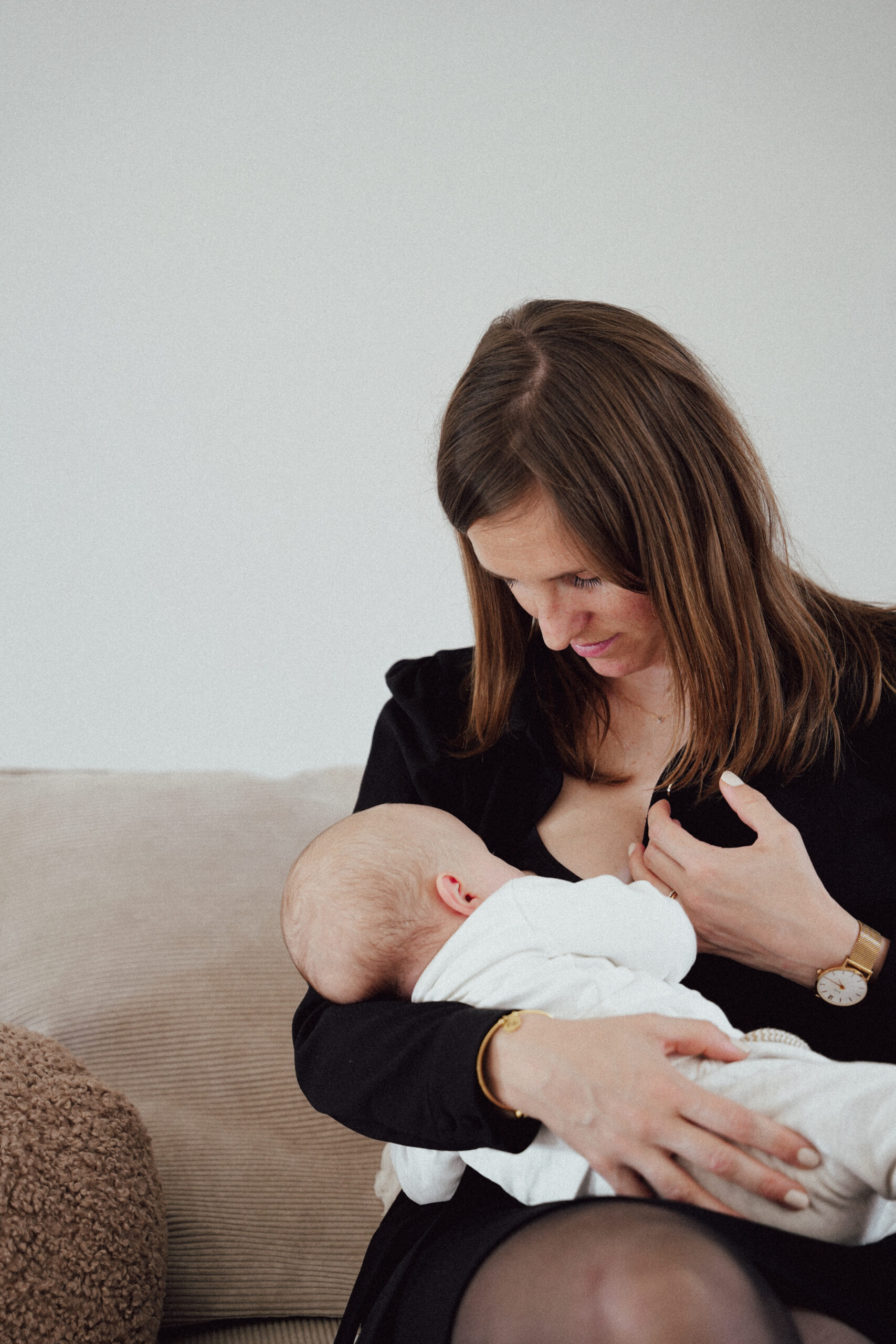 Maman souriante allaitant son bébé dans un cadre naturel